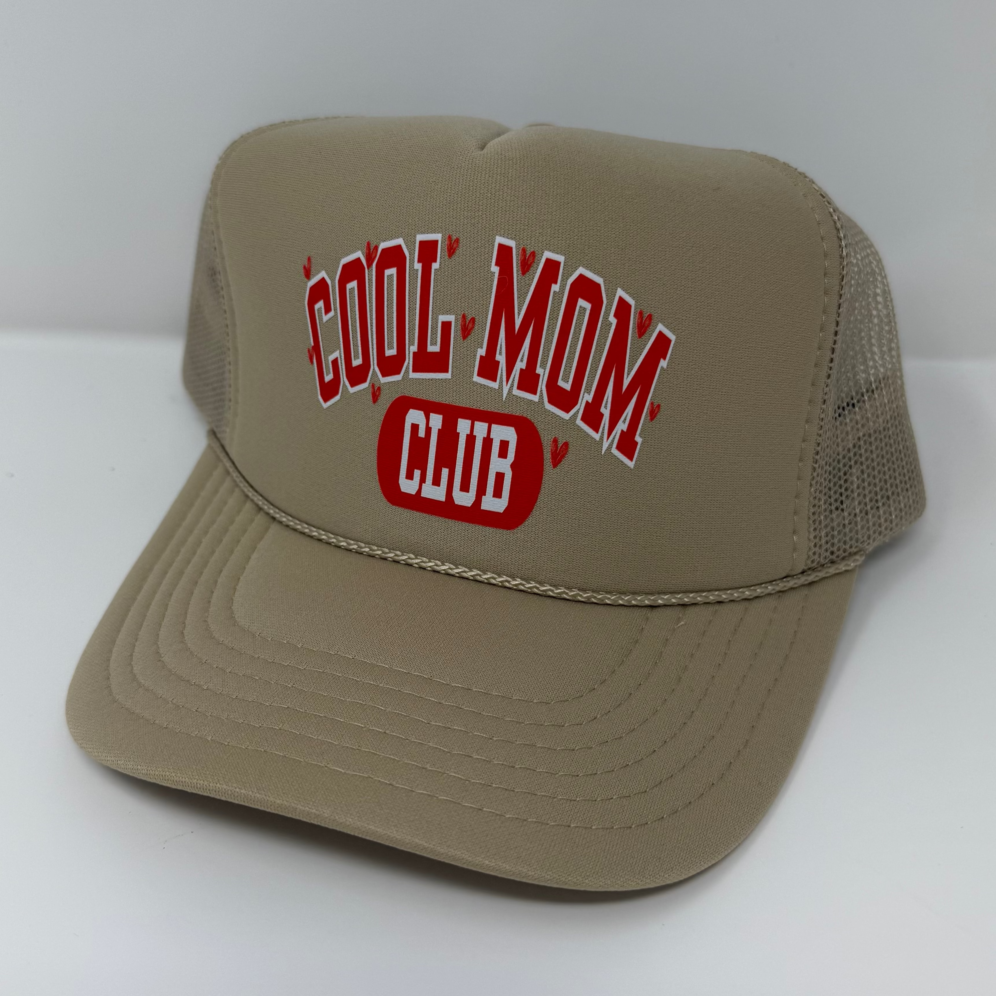 Beige cap with 'Cool Mom Club' text on a white background
