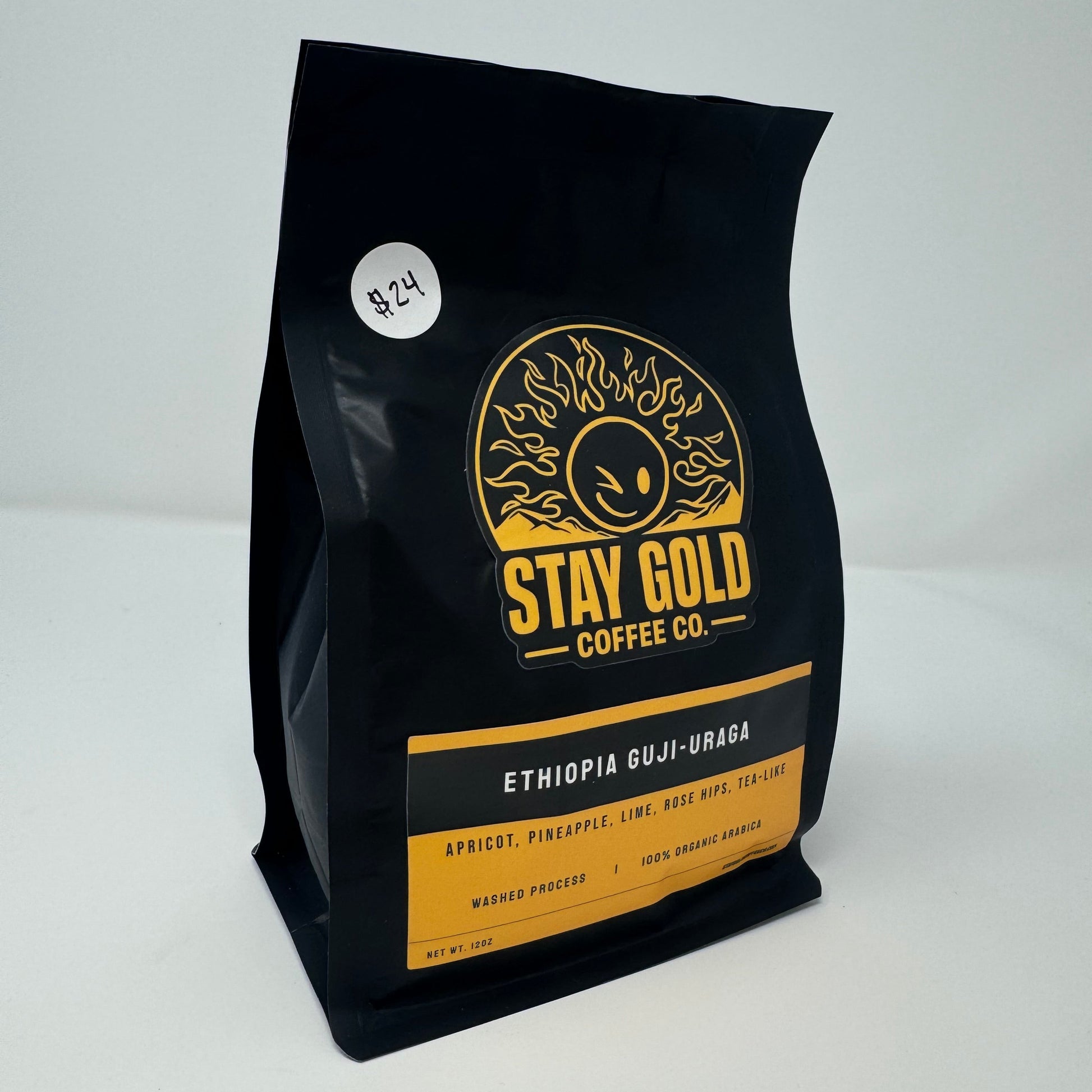 Black coffee bag with gold and white text on a white background