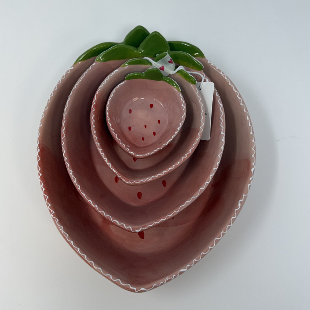 Set of four strawberry-shaped ceramic dishes on a white background